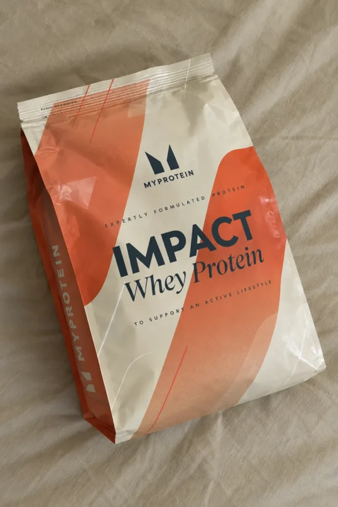 MyProtein Impact Whey Protein pouch lying on a bed