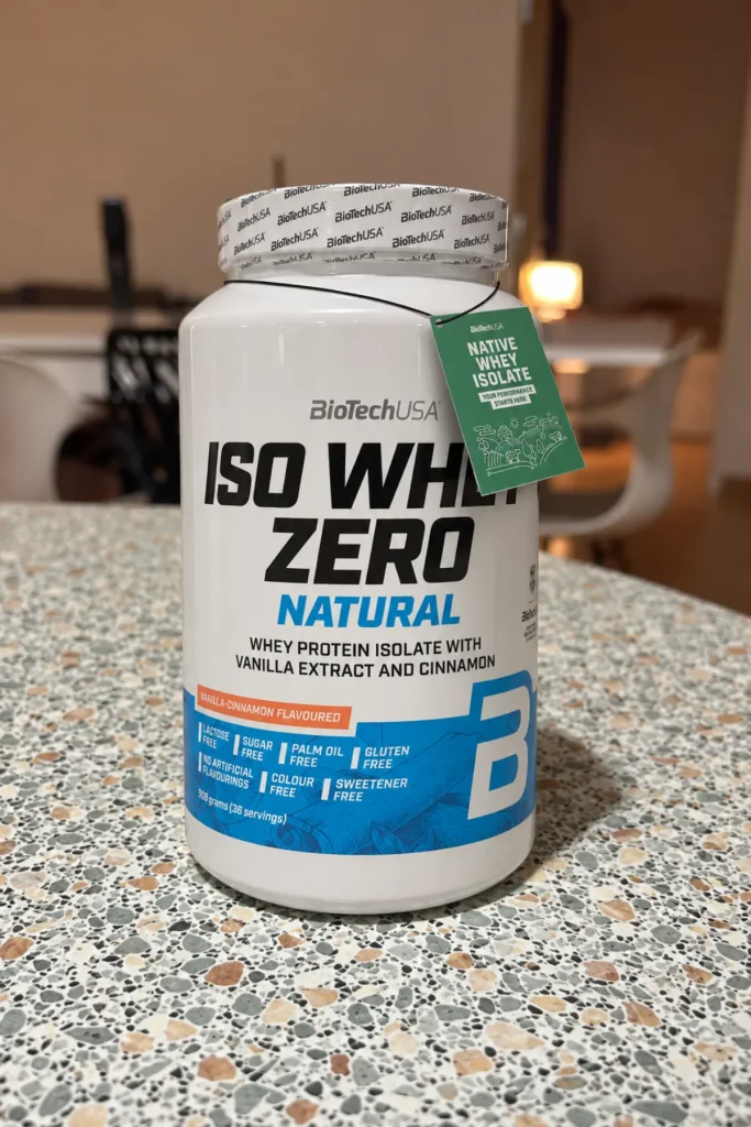 Pot blanc d'Iso Whey Zero Natural BioTechUSA vanille cannelle posé sur un plan de travail